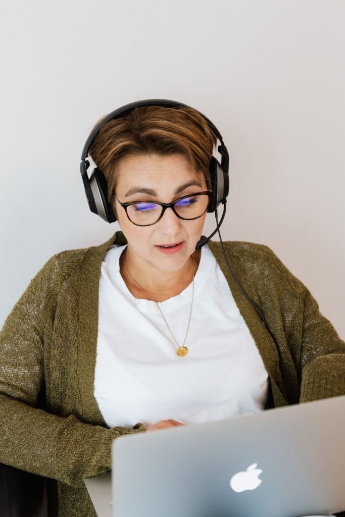 Woman wearing a headset working on a laptop at home